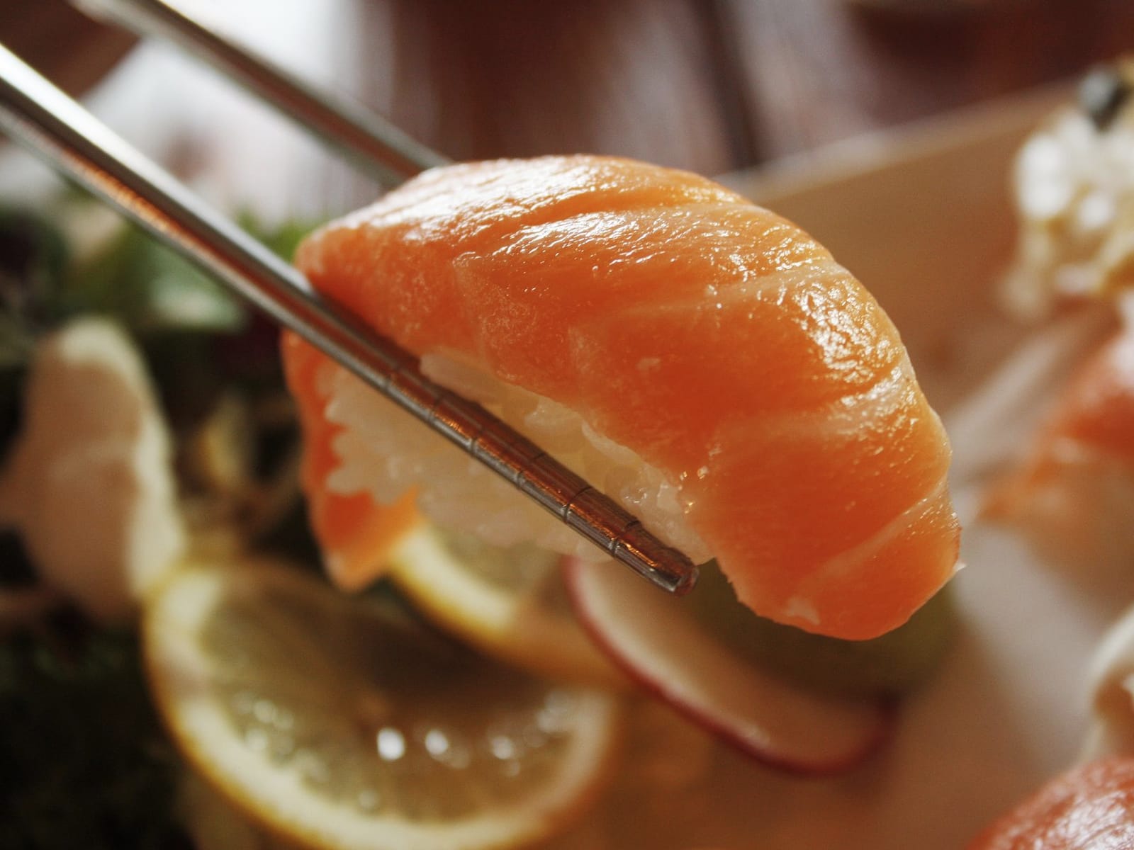 Nigiri de salmão segurado por hashi